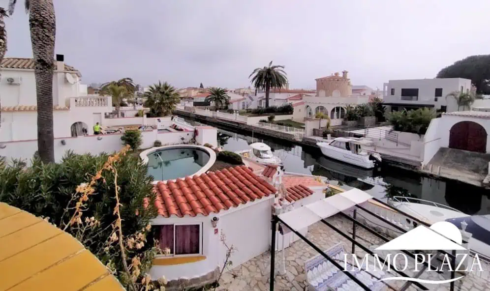 Vila al canal de 2 apartaments (4 dormitoris) amb amarratge de 12,5m, piscina i garatge. Terreny 500m2.