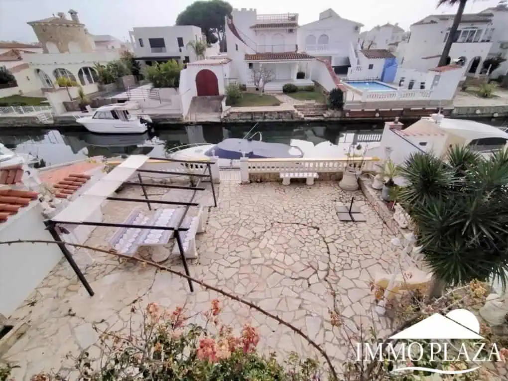 Vila al canal de 2 apartaments (4 dormitoris) amb amarratge de 12,5m, piscina i garatge. Terreny 500m2.