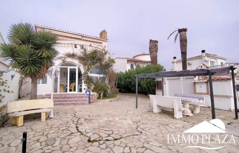 Vila al canal de 2 apartaments (4 dormitoris) amb amarratge de 12,5m, piscina i garatge. Terreny 500m2.