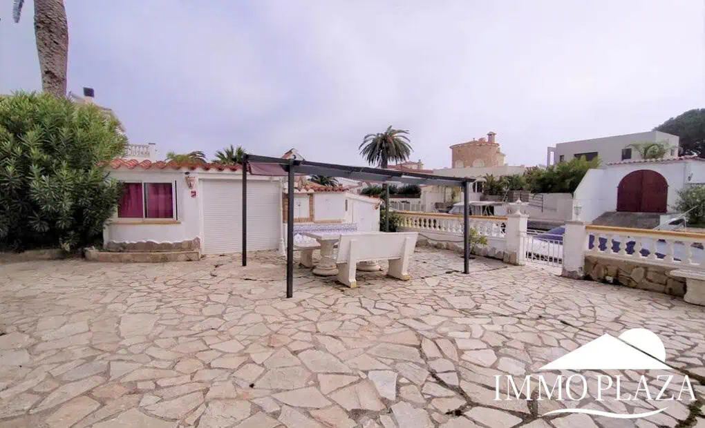 Vila al canal de 2 apartaments (4 dormitoris) amb amarratge de 12,5m, piscina i garatge. Terreny 500m2.