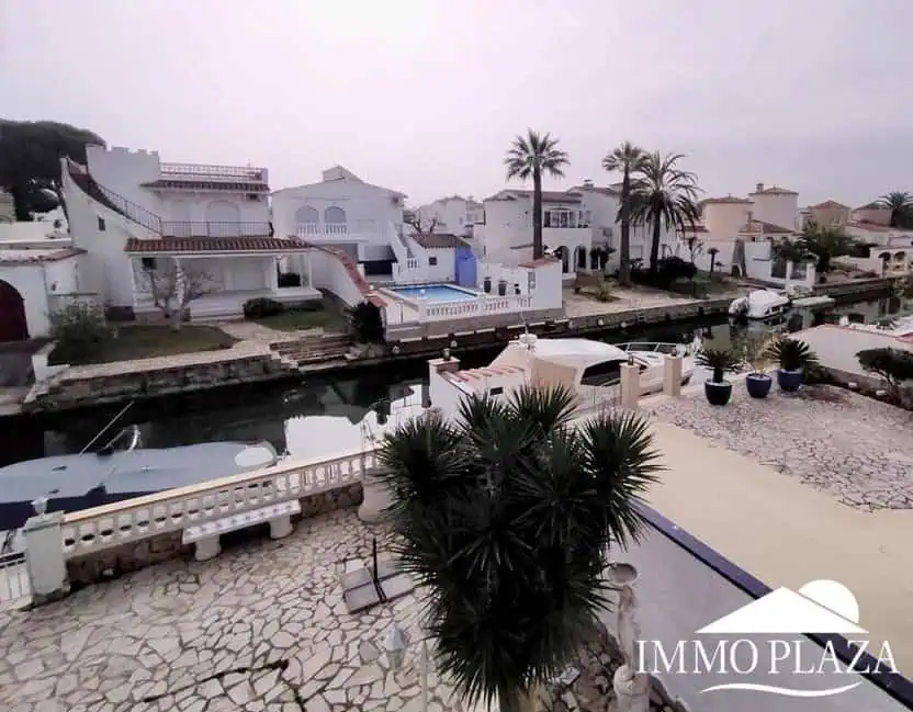 Vila al canal de 2 apartaments (4 dormitoris) amb amarratge de 12,5m, piscina i garatge. Terreny 500m2.