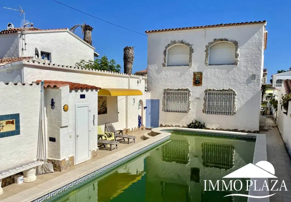 Vila al canal de 2 apartaments (4 dormitoris) amb amarratge de 12,5m, piscina i garatge. Terreny 500m2.