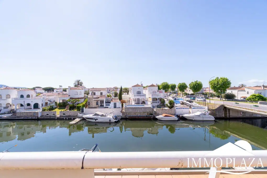 Appartement moderne avec vue sur le canal, 2 chambres, grande terrasse 40m2, débarras et parking. Piscine, jardin et amarrage commun.